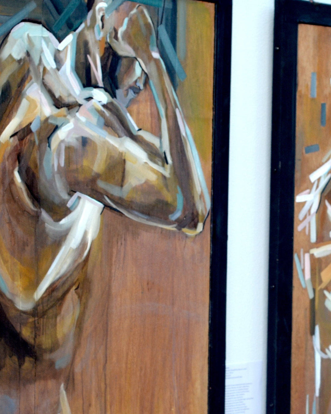 Three framed artworks of abstract human figures on a wall.